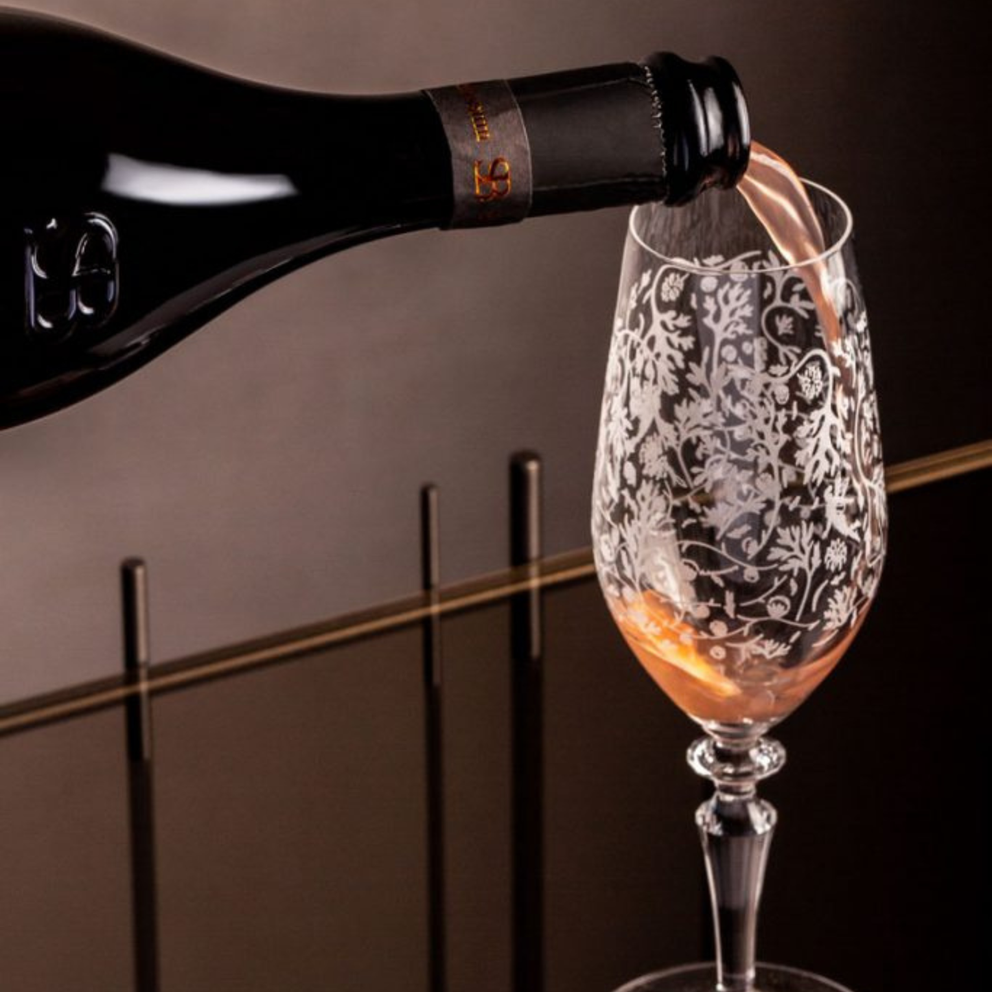 Wine bottle being poured into a decorative glass with a blurred background