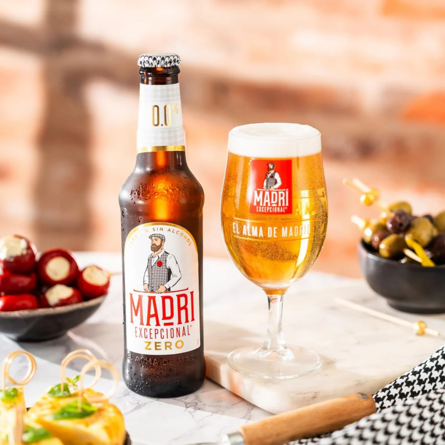 Bottle and glass of Madri beer with snacks on a table