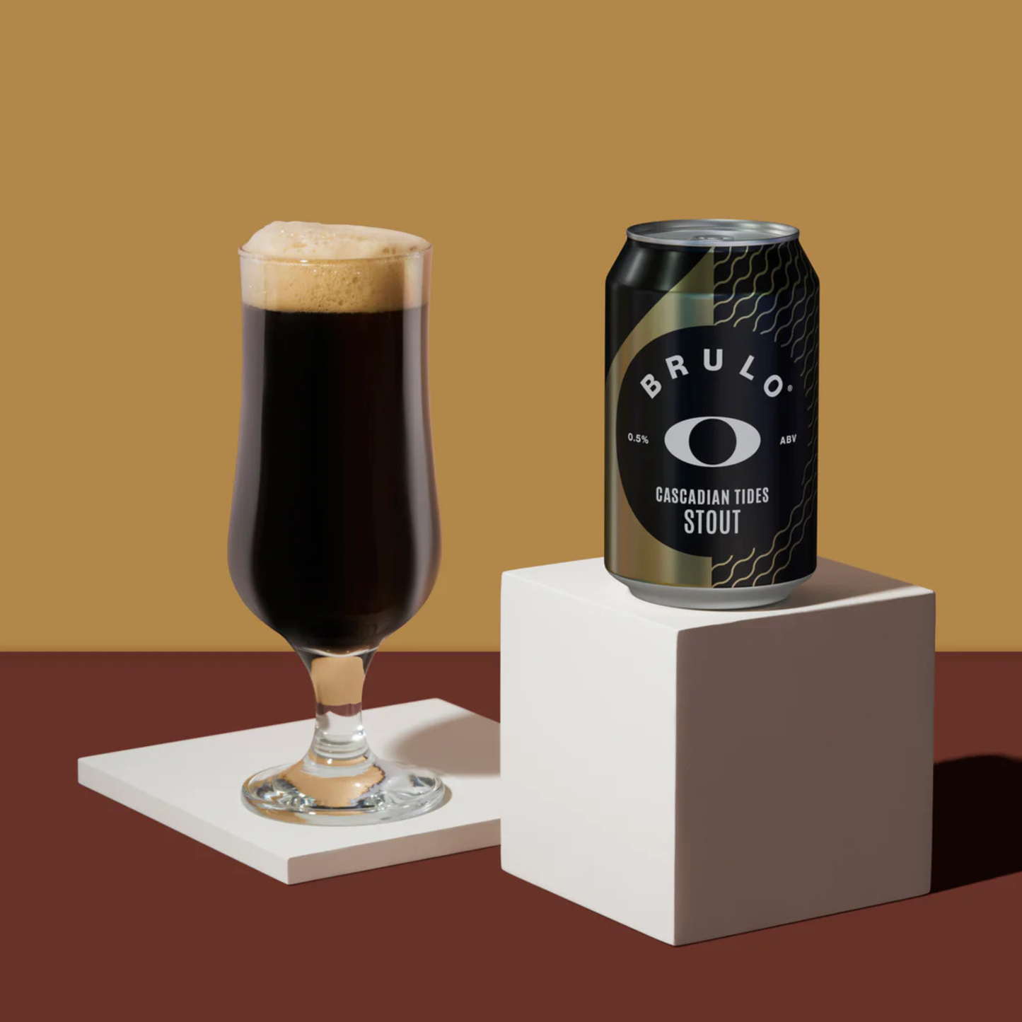 Glass of dark beer with a can labeled 'BRULO' on a brown background
