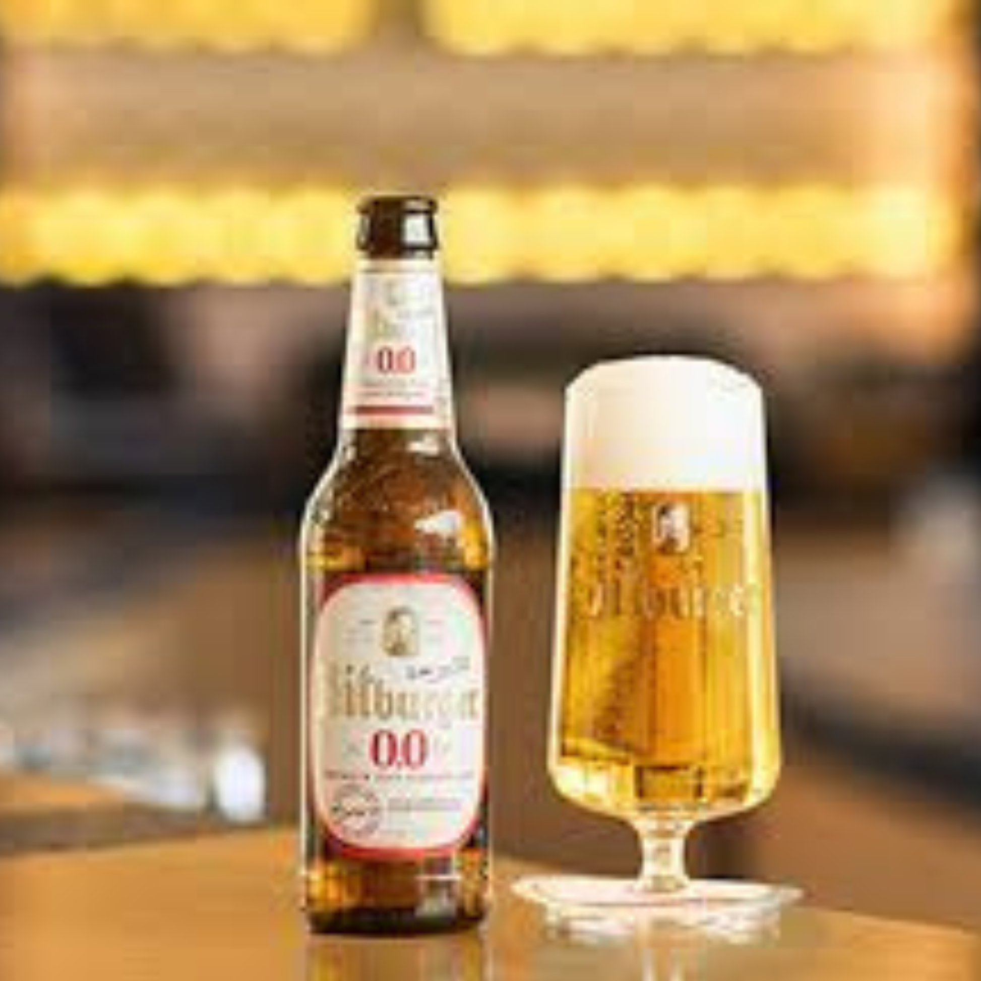 Albaniq beer bottle and glass on a wooden surface with a blurred background