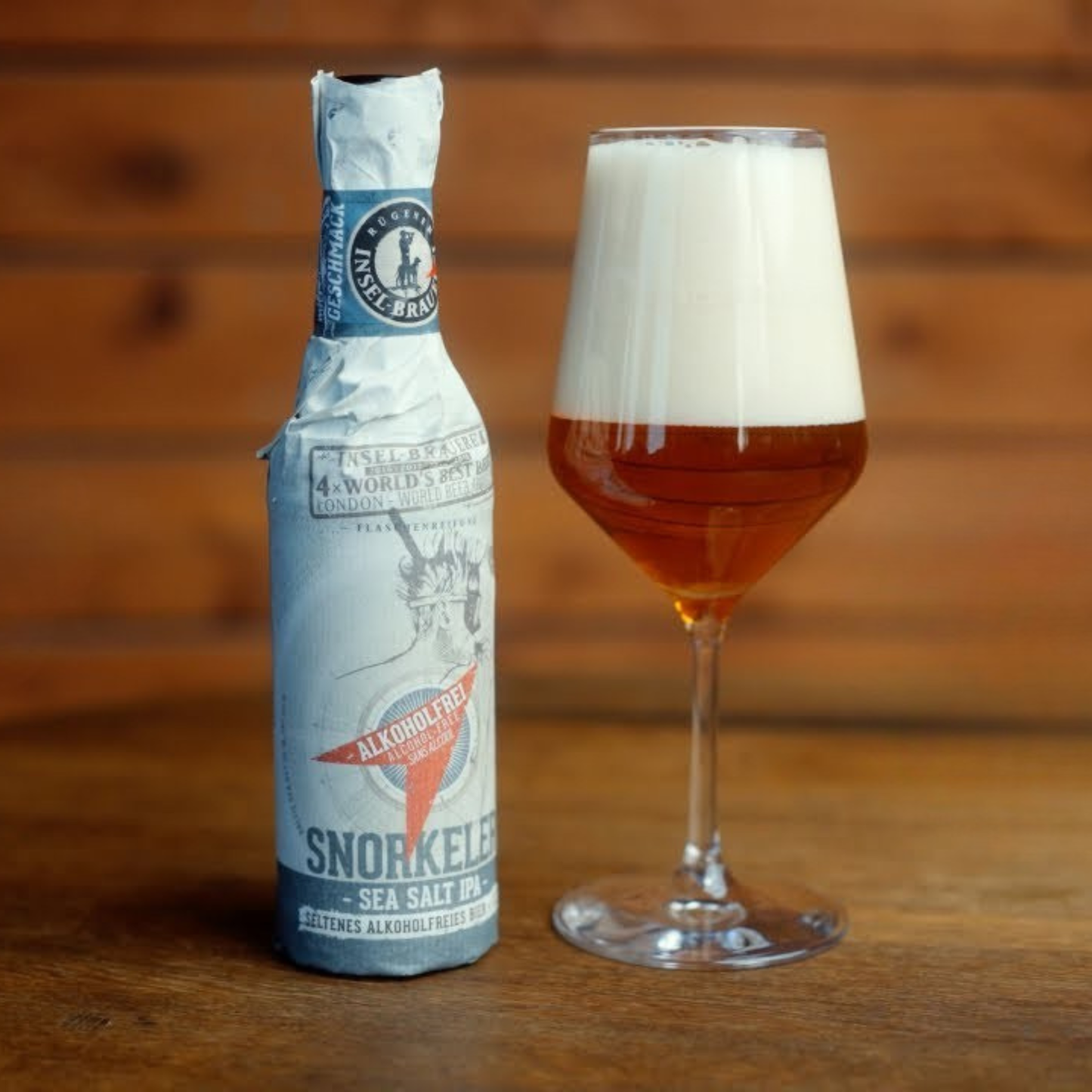 Bottle of Snorkel beer with a glass of beer on a wooden surface