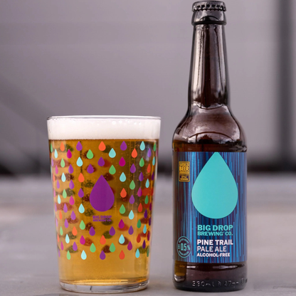 Alcohol-free beer bottle and glass with colorful design on a gray background