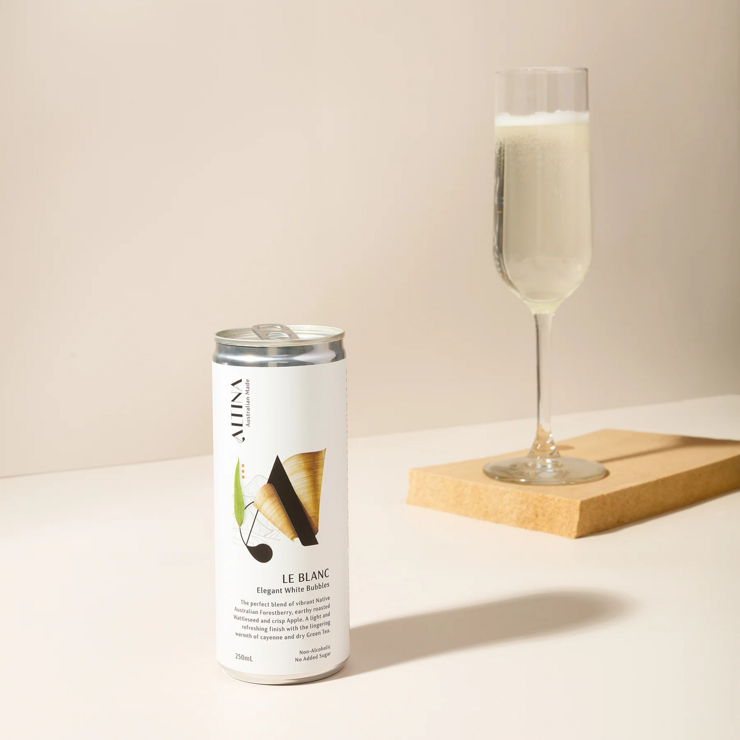Alina Le Blanc sparkling wine can with a glass of champagne on a light surface.