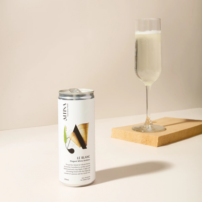 Alina Le Blanc sparkling wine can with a glass of champagne on a light surface.