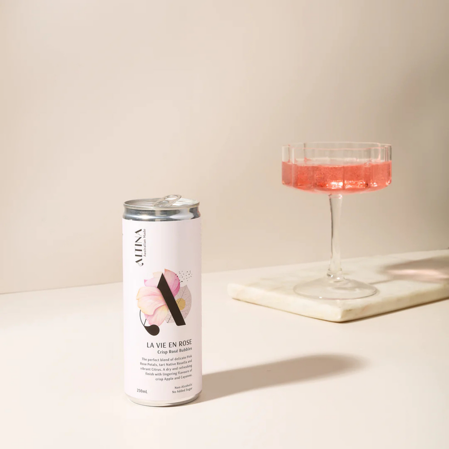 Alma La Vie en Rose can and glass with pink liquid on a light background