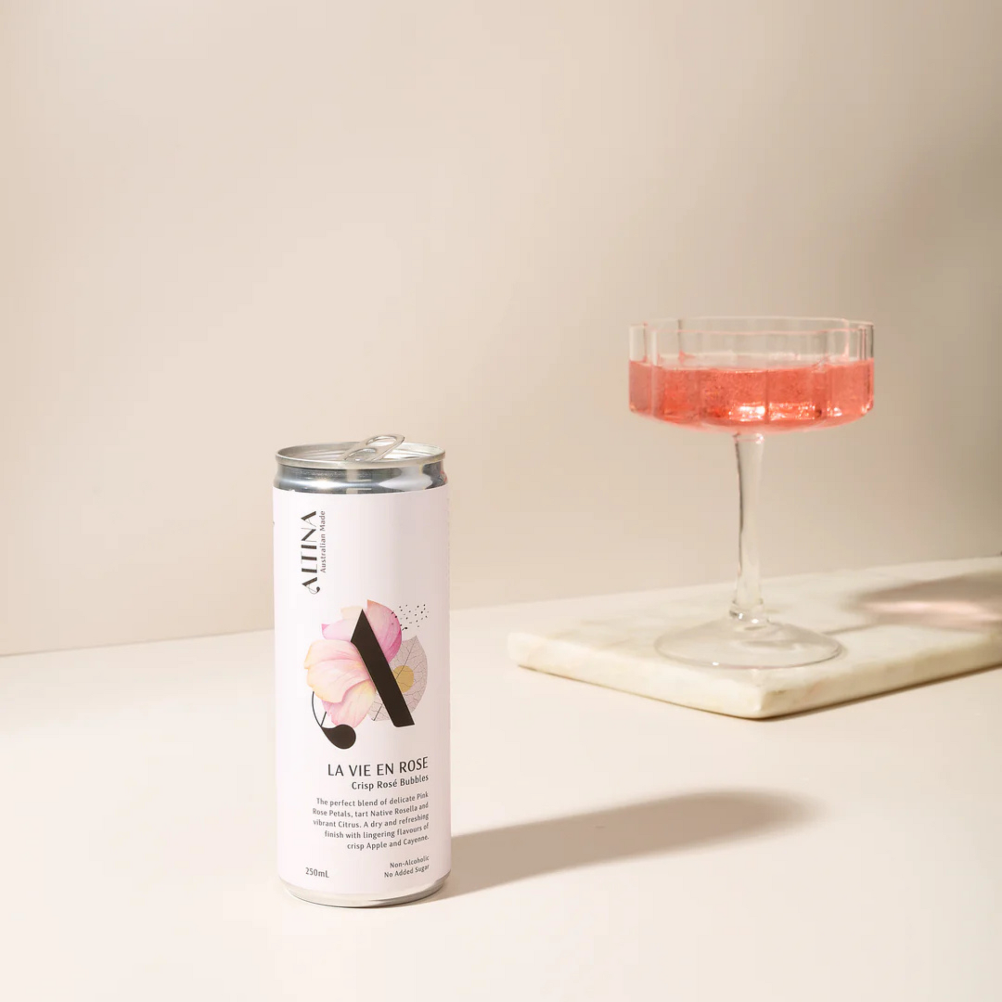 Alma La Vie en Rose can and glass with pink liquid on a light background