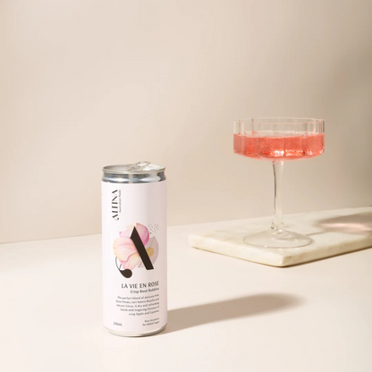 Alma La Vie en Rose can and glass with pink liquid on a light background