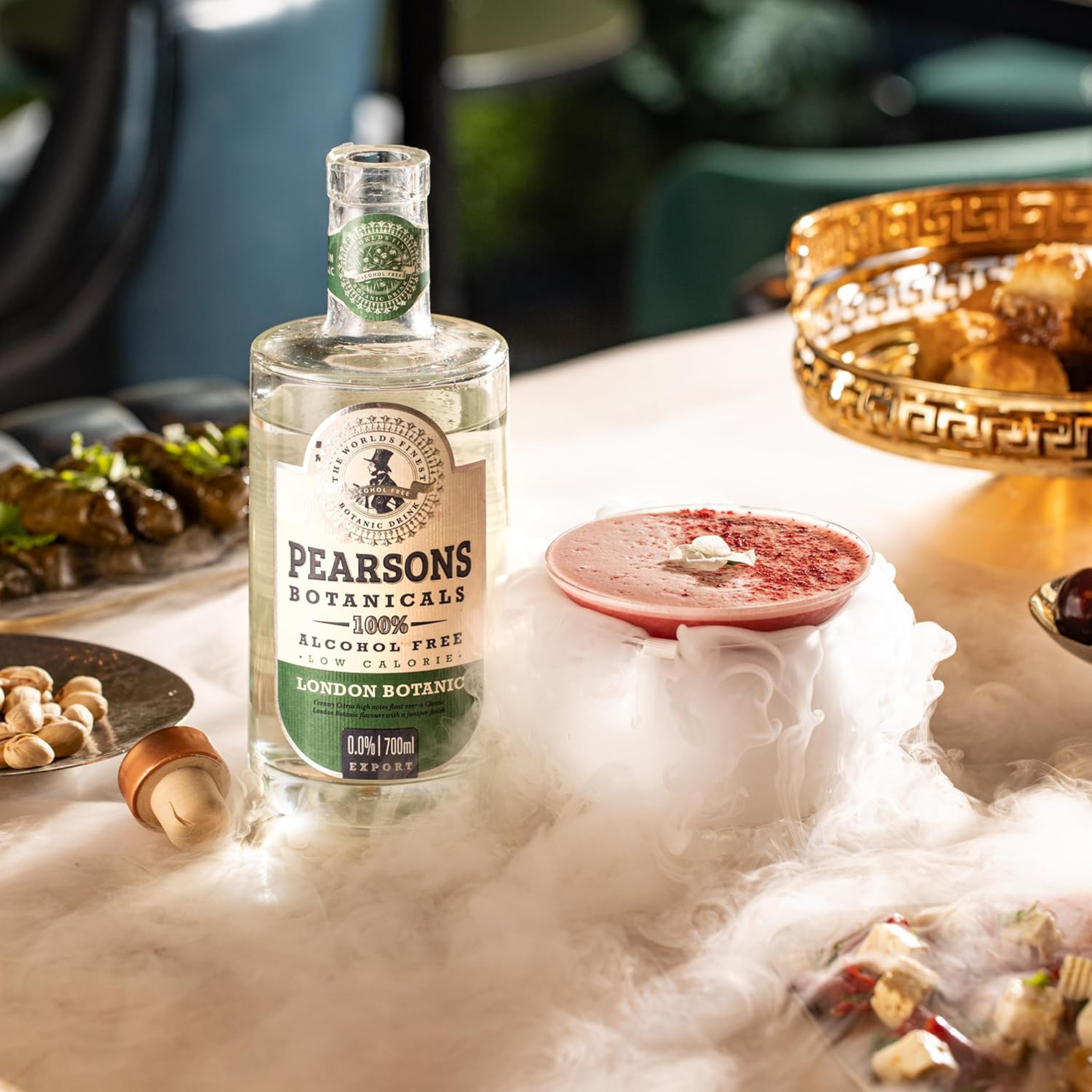 Pearsons Botanicals alcohol-free gin bottle on a table with snacks and drinks.